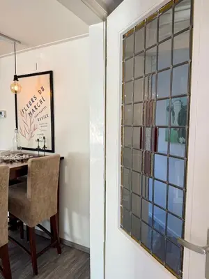 a glass block window in a dining room with a table at Noordwijk-sur-mer in Noordwijk aan Zee