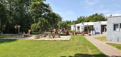 a park with a picnic table and a building at Het Dijkhuysje by ZILT in Warmenhuizen
