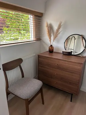 a dressing room with a chair and a mirror on a dresser at Het Dijkhuysje by ZILT in Warmenhuizen