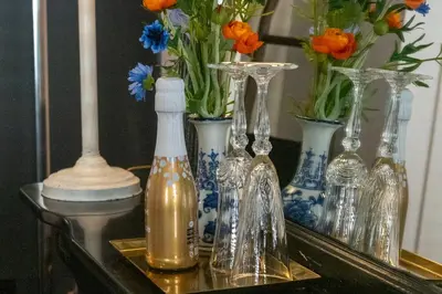 a group of glass vases on a table with flowers at Guesthouseamsterdam in Amsterdam
