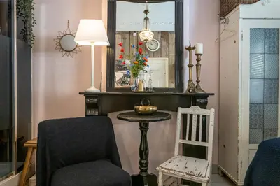 a room with a chair and a table and a mirror at Guesthouseamsterdam in Amsterdam