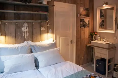 a bedroom with a white bed and a sink at Guesthouseamsterdam in Amsterdam