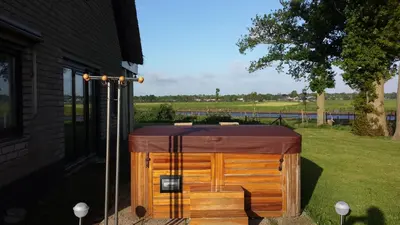 a wooden hot tub with a brown cover on a yard at B&B Krachtwijk in Soest