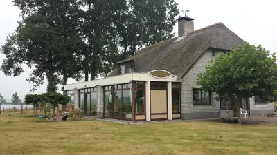 a small house with glass windows on a field at B&B Krachtwijk in Soest