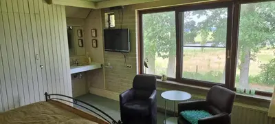 a room with two chairs and a table and a tv at B&B Krachtwijk in Soest