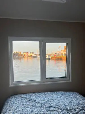 a bedroom window with a view of a body of water at Bed en B-ootje in Bunschoten