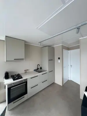 a kitchen with white cabinets and a sink at Bed en B-ootje in Bunschoten