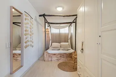 a small room with a bed and a mirror at Beachhouse Jula in Egmond aan Zee