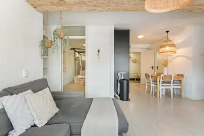 a living room with a couch and a dining room at Beachhouse Jula in Egmond aan Zee