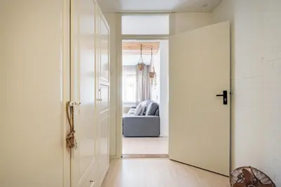 an open door leading to a room with a couch at Beachhouse Jula in Egmond aan Zee