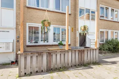 a house with a wooden fence in front of it at Beachhouse Jula in Egmond aan Zee