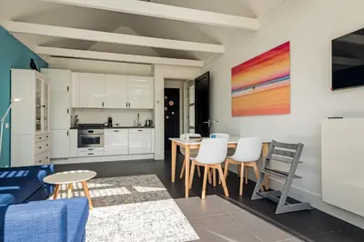 a kitchen and dining room with a table and chairs at Dune Haven in Schoorl