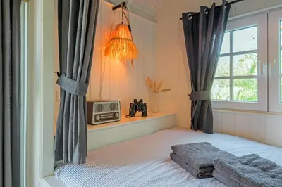 a bedroom with a bed and a window and a radio at Nature lovers Amsterdam Zaandam in Wijdewormer