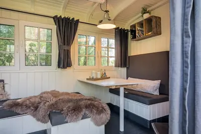 a dining room with a table and a fur rug at Nature lovers Amsterdam Zaandam in Wijdewormer