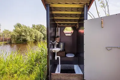 a bathroom on a boat on a river at Nature lovers Your own island in Wijdewormer