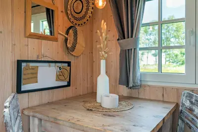 a wooden wall with a table with a vase on it at Nature lovers Your own island in Wijdewormer