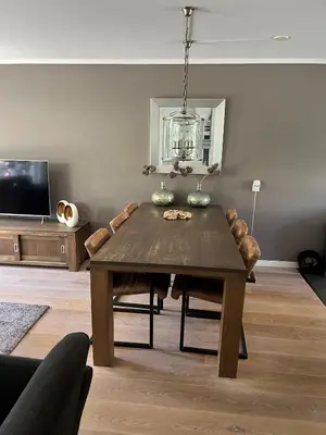 a living room with a wooden table and a tv at Perla di Robbie in Zandvoort