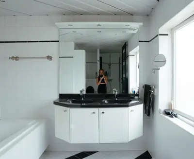 a person taking a picture of a bathroom with a mirror at Perla di Robbie in Zandvoort