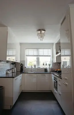 a kitchen with white cabinets and a large window at Perla di Robbie in Zandvoort