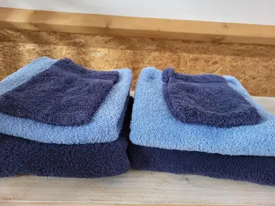 two blue knitted towels sitting on a wooden floor at De Gortla in Oosterblokker