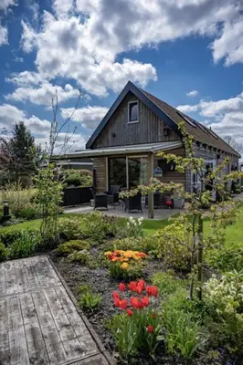 a garden with flowers in front of a house at De Gortla in Oosterblokker