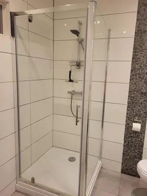 a shower with a glass door in a bathroom at De Gortla in Oosterblokker