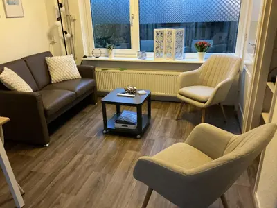 a living room with couches and chairs and a table at Zomerhuis Zwart in Egmond aan Zee