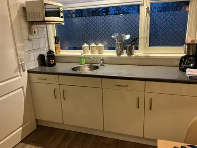 a kitchen with a sink and a window at Zomerhuis Zwart in Egmond aan Zee
