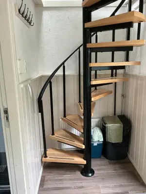 a spiral staircase with wooden steps in a room at Zomerhuis Zwart in Egmond aan Zee