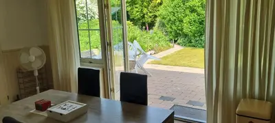 a dining room with a table and a sliding glass door at Ruime vakantievilla in Zeewolde in Zeewolde