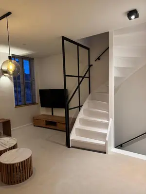 a living room with a staircase and a tv at Casa del Cisne 4 in Zandvoort