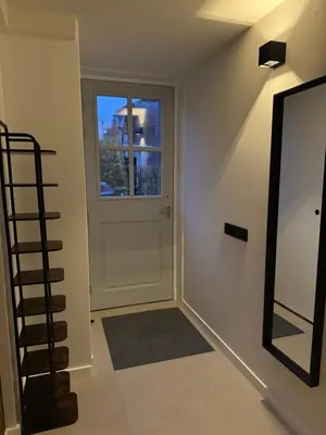 a hallway with a white door and a window at Casa del Cisne 4 in Zandvoort