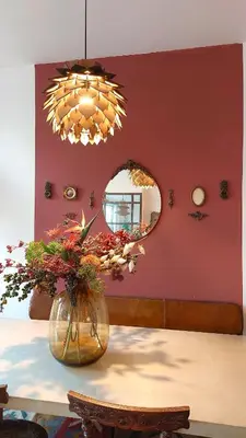 a vase with flowers on a table with a mirror at Canal House with a Unique View in Amsterdam