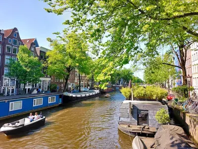 a group of people in boats on a canal at Canal House with a Unique View in Amsterdam