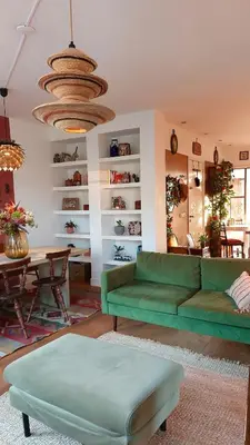 a living room with a green couch and a table at Canal House with a Unique View in Amsterdam