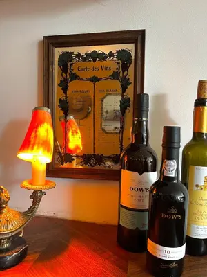 three bottles of wine sitting on a table with a lamp at Canal House with a Unique View in Amsterdam