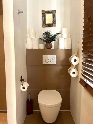 a bathroom with a toilet and a shelf with toilet paper at Canal House with a Unique View in Amsterdam