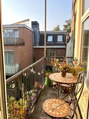 a balcony with a table and chairs on a balcony at Canal House with a Unique View in Amsterdam