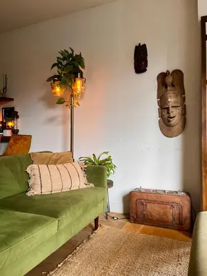 a living room with a green couch and a head on the wall at Canal House with a Unique View in Amsterdam