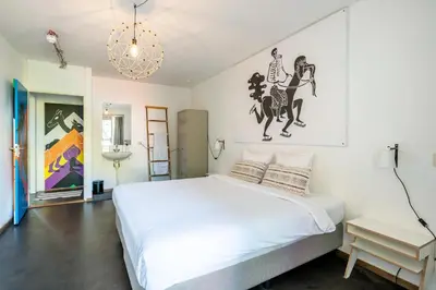 a bedroom with a white bed and a chandelier at Apartment Hotel Zuid Oost Heesterveld BnB ZOH in Amsterdam