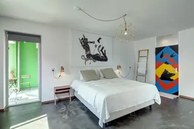 a white bedroom with a large bed and a chandelier at Apartment Hotel Zuid Oost Heesterveld BnB ZOH in Amsterdam