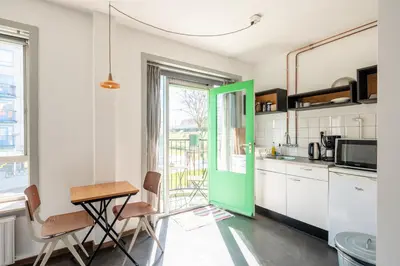 a kitchen with a green door and a table at Apartment Hotel Zuid Oost Heesterveld BnB ZOH in Amsterdam