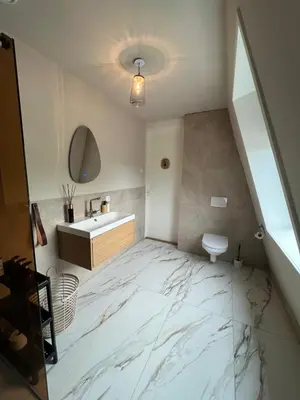 a bathroom with a sink and a white marble floor at Luxury Private Spa with golden bath, cinema and sauna in Bodegraven