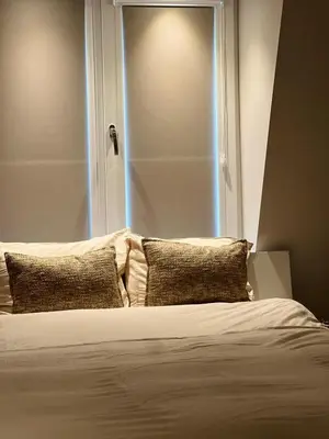 a bed with two pillows in front of a window at Luxury Private Spa with golden bath, cinema and sauna in Bodegraven