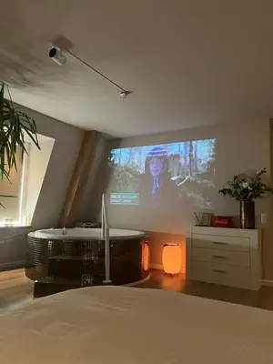a room with a projection screen with a woman on it at Luxury Private Spa with golden bath, cinema and sauna in Bodegraven