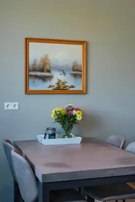a dining room table with a vase of flowers on it at Logeer aan de Geer in Wilnis