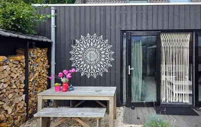 a patio with a wooden table and flowers on a fence at 1 Bedroom Lovely Home In Heiloo in Heiloo
