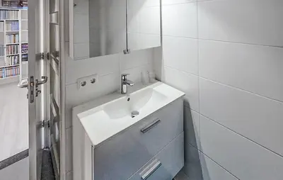 a white bathroom with a sink and a mirror at 1 Bedroom Lovely Home In Heiloo in Heiloo