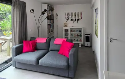 a living room with a gray couch with pink pillows at 1 Bedroom Lovely Home In Heiloo in Heiloo