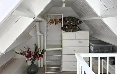 an attic room with a staircase and a vase with flowers at 1 Bedroom Lovely Home In Heiloo in Heiloo